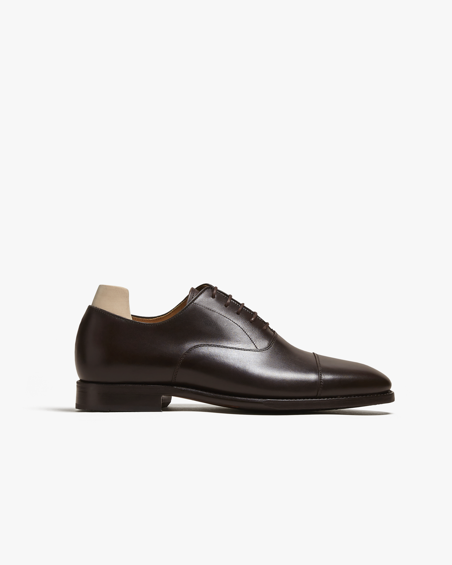 A side profile shot of Äppelviken – Dark Brown Calf, a cap toe Oxford shoe, detailing its sleek silhouette.