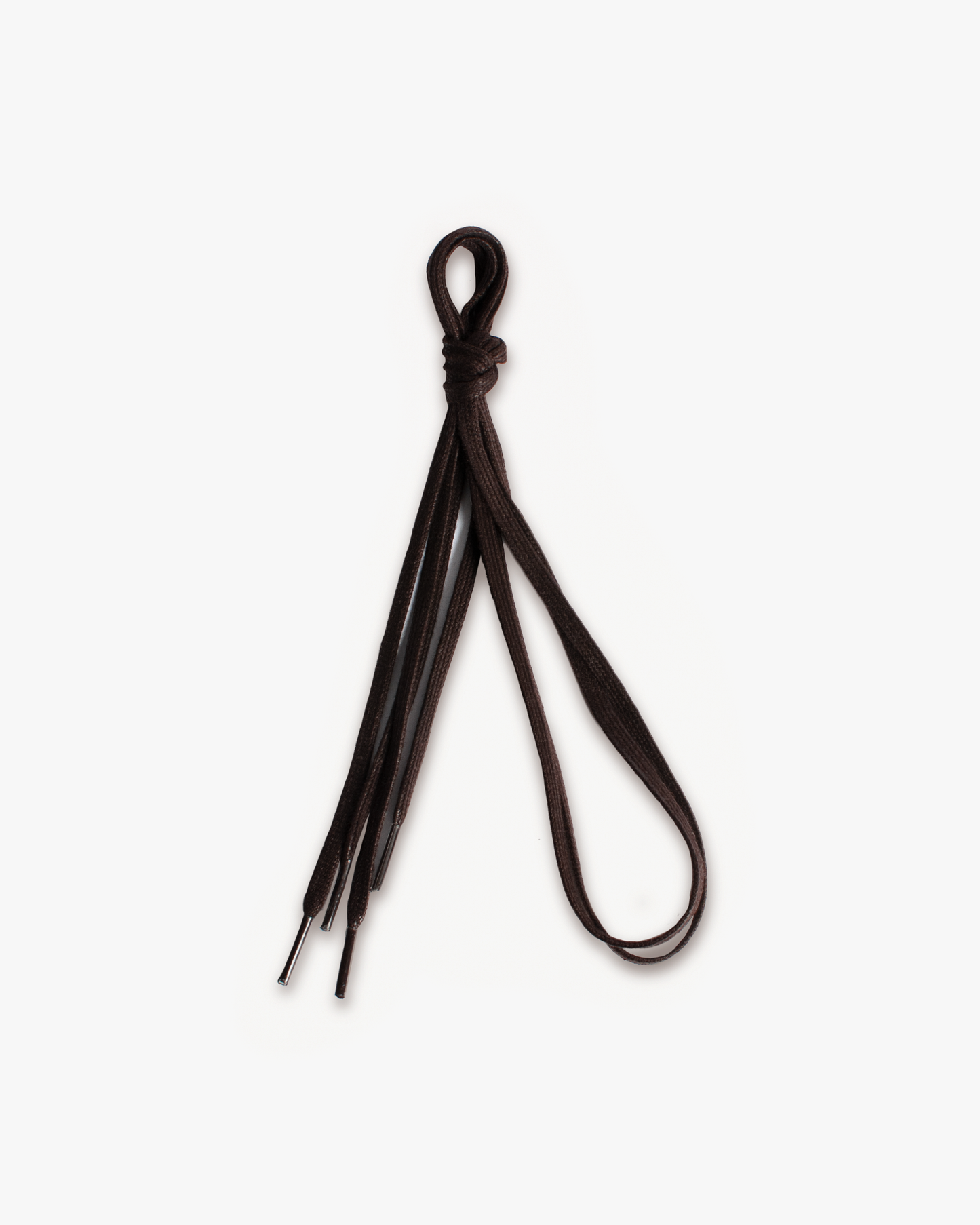 A pair of brown flat waxed shoelaces tied in a knot, shot against a plain white background.