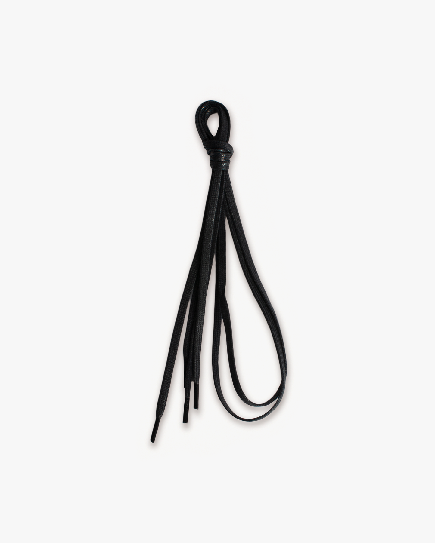 A pair of black, flat waxed shoelaces, tied together in a simple knot against a white background.