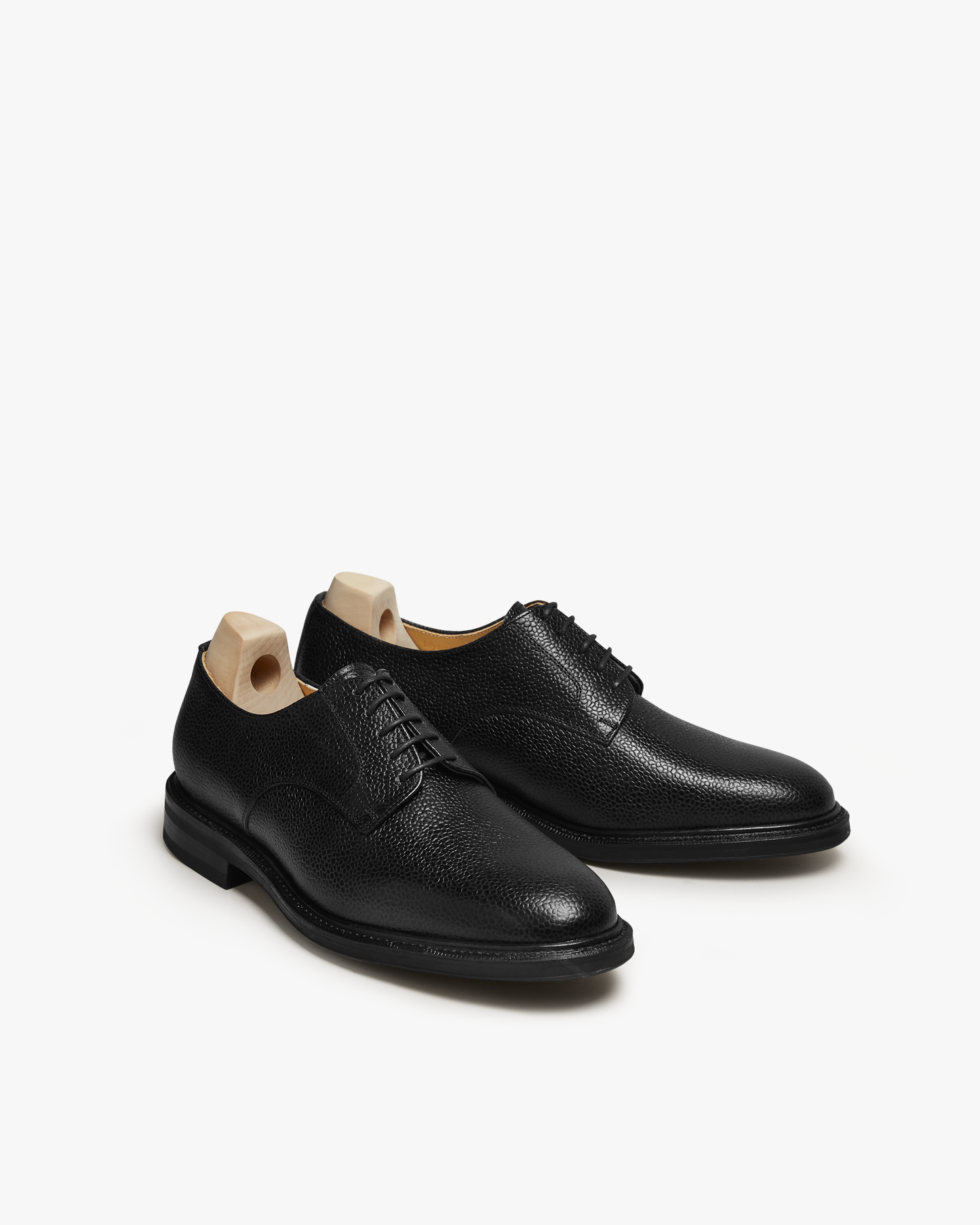 A pair of Boden – Black Country Calf derby shoes in black grained leather, shown with shoe trees on a white background.