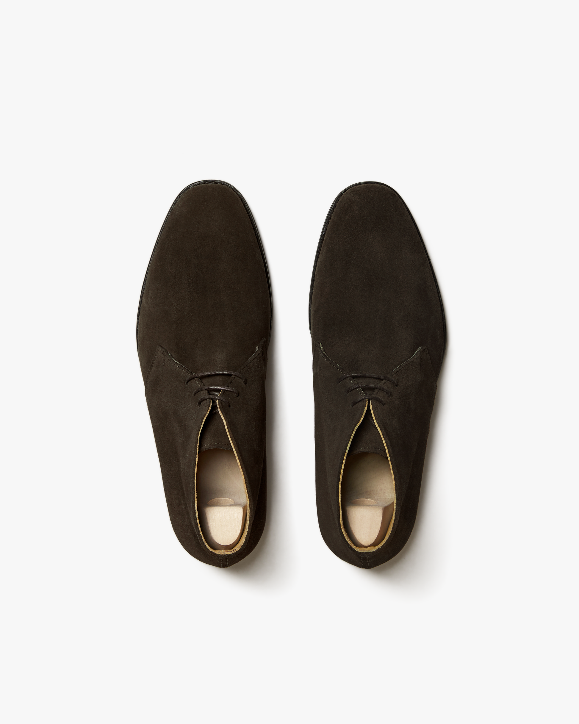 A pair of Gyllsjö – Dark Brown Suede chukka boots shot from above on a clean white background.