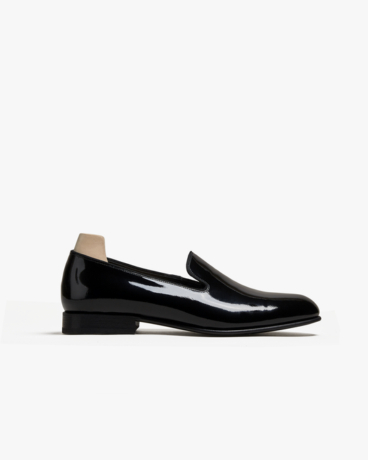 A side profile of the Muskö – Black Patent Leather loafer, showcasing its sleek silhouette and high-gloss patent finish.
