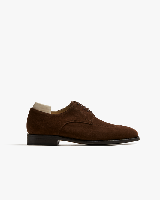 Side profile of Norrmalm – Dark Snuff Suede, a split-toe derby presented with a wooden shoe tree.