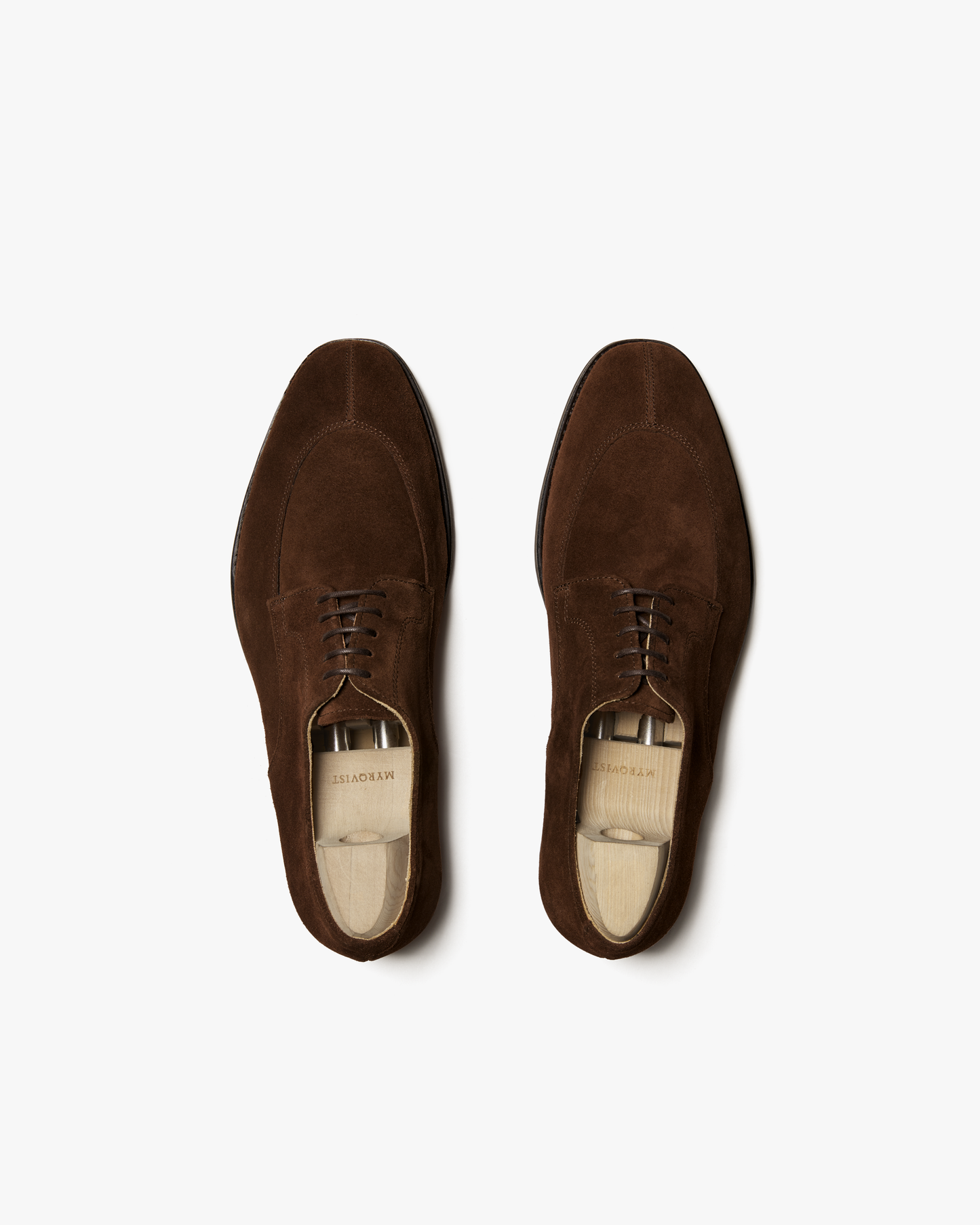 A pair of Norrmalm – Dark Snuff Suede split-toe derbys with shoe trees inside, photographed from above.