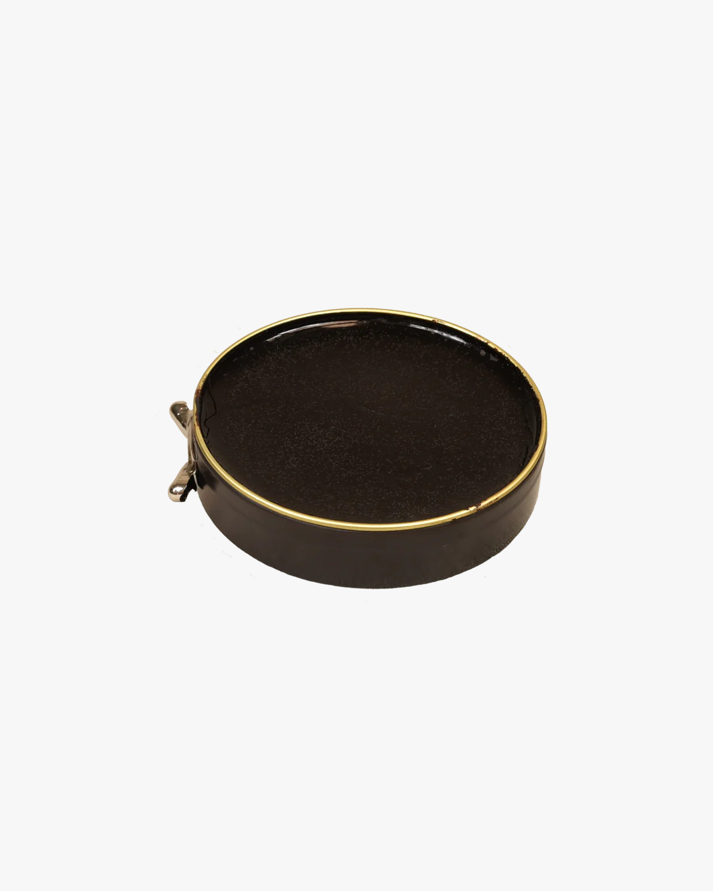 An open tin of Saphir – Pâte de Luxe shoe wax, revealing the dark polish within its gold-rimmed container.