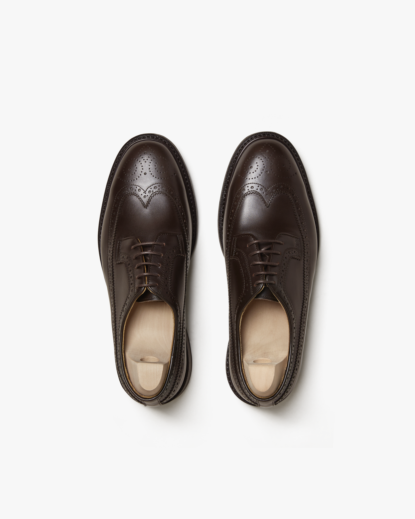 A top-down photograph of Orust – Dark Brown Calf, a long-wing Derby showcasing its intricate brogue details.