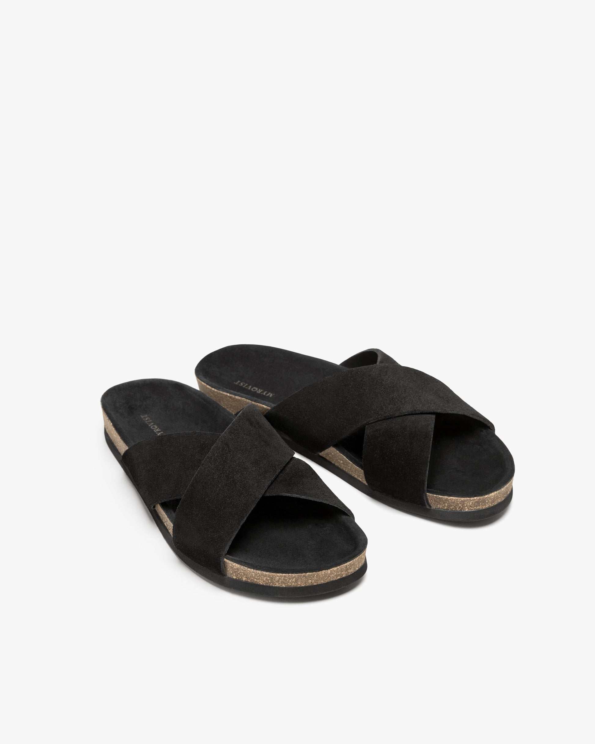 Three-quarter view of Solvik – Black Suede sandals, highlighting the criss-cross straps and moldable cork sole.