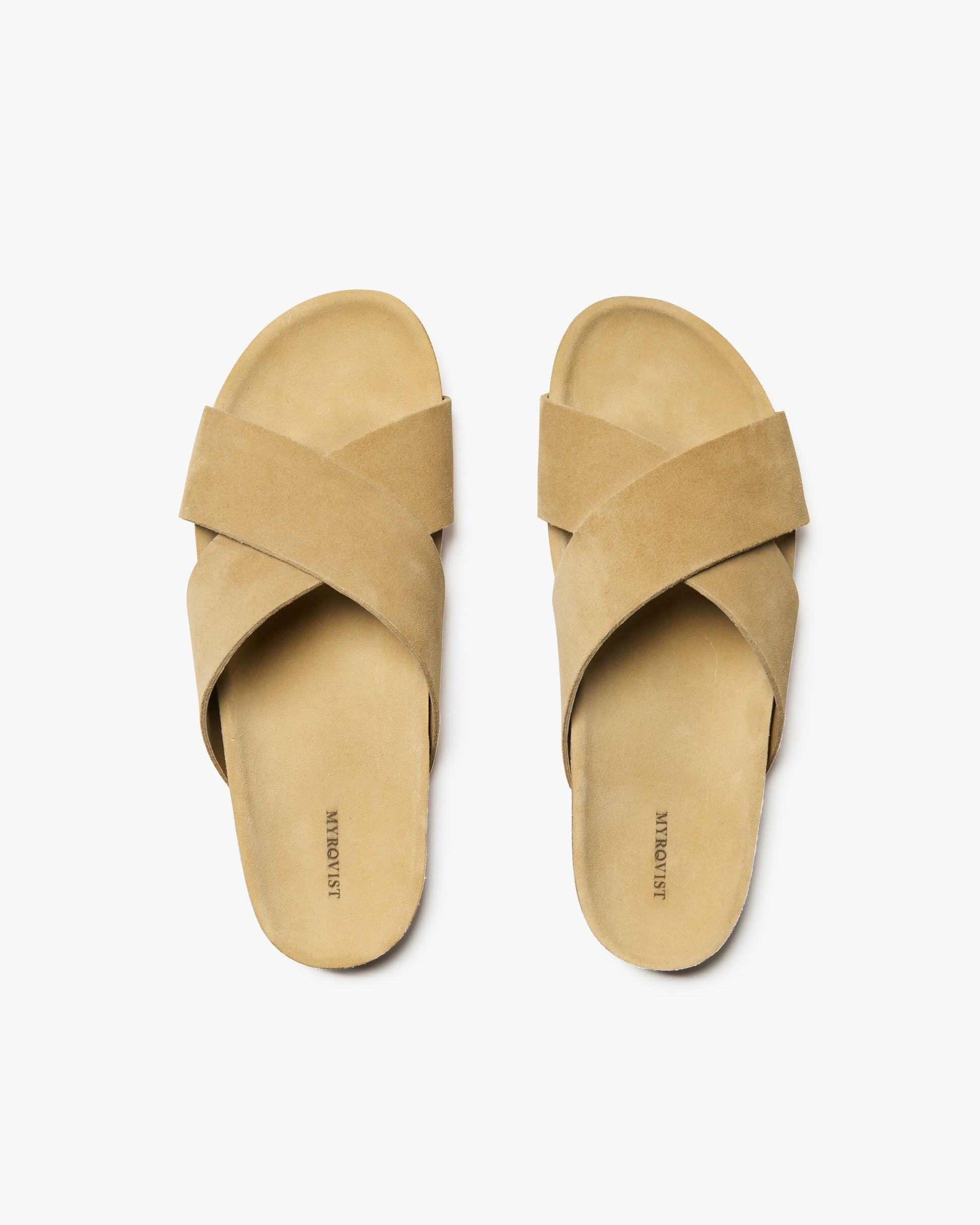 An overhead view of the Solvik – Sand Suede sandals, showcasing their minimalist criss-cross design in soft suede.