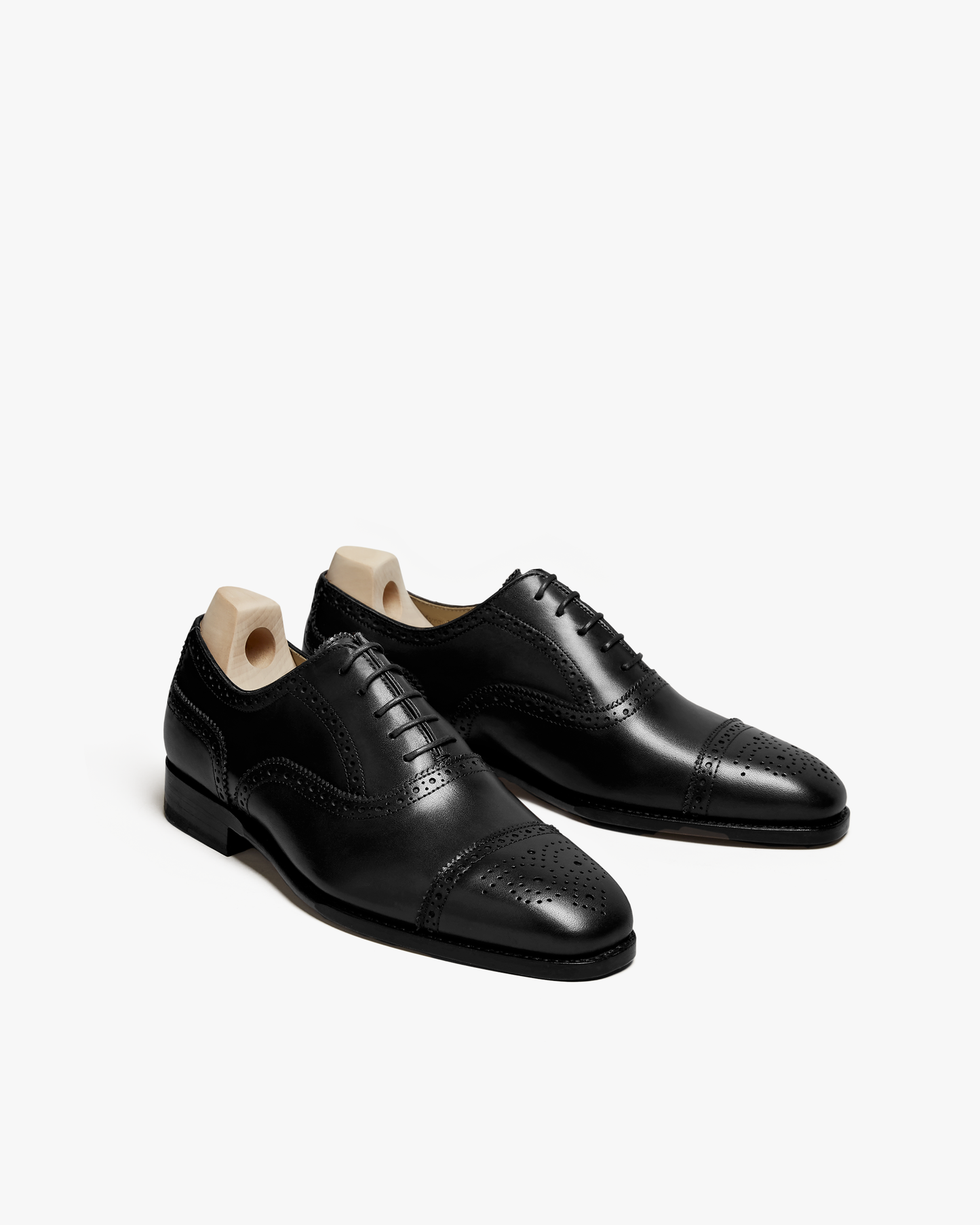 A pair of Strömsö – Black Calf semi-brogue Oxfords with shoe trees, shot against a white background.