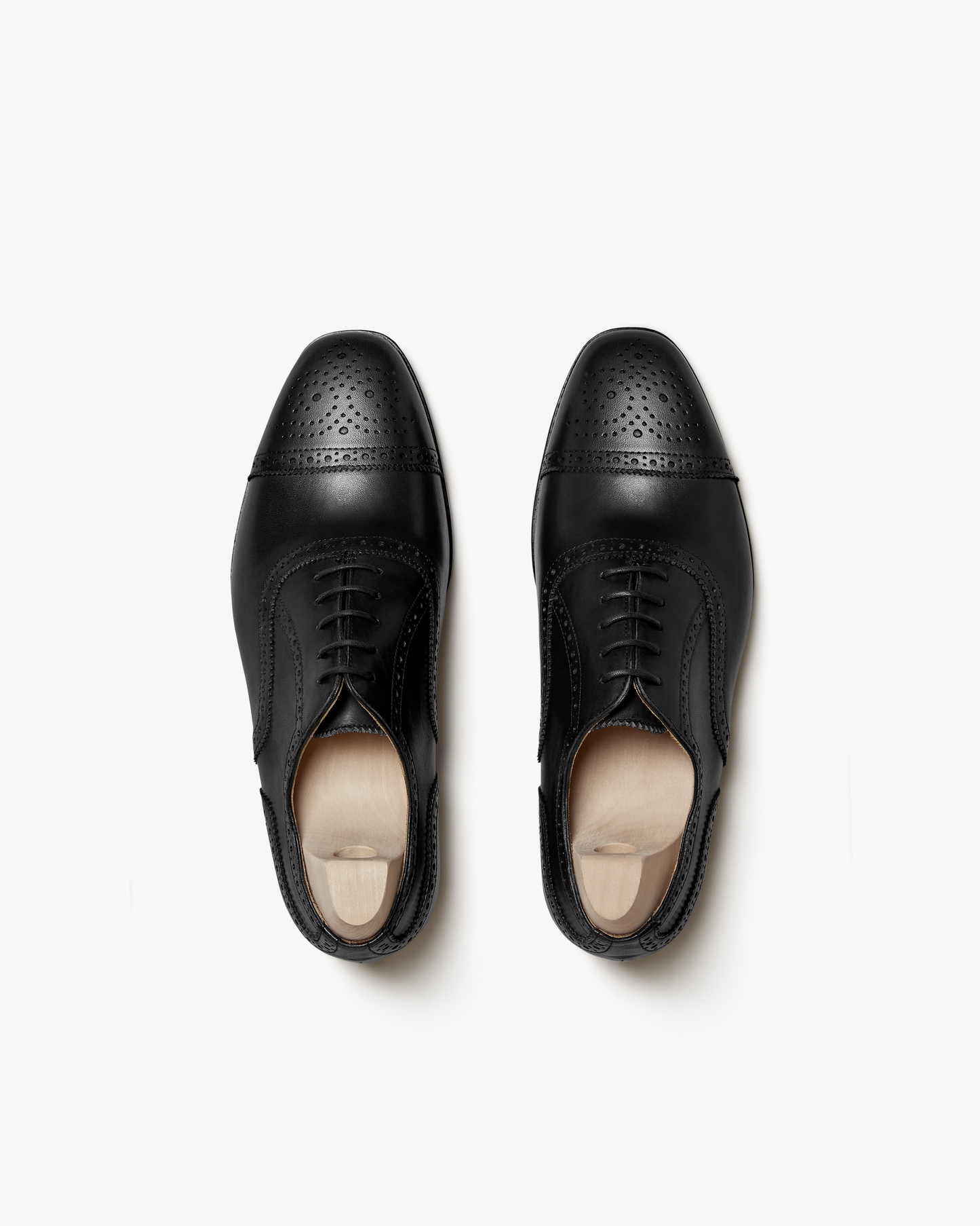 A pair of Strömsö – Black Calf semi-brogue Oxfords with shoe trees, shown in a top-down view on a white background.