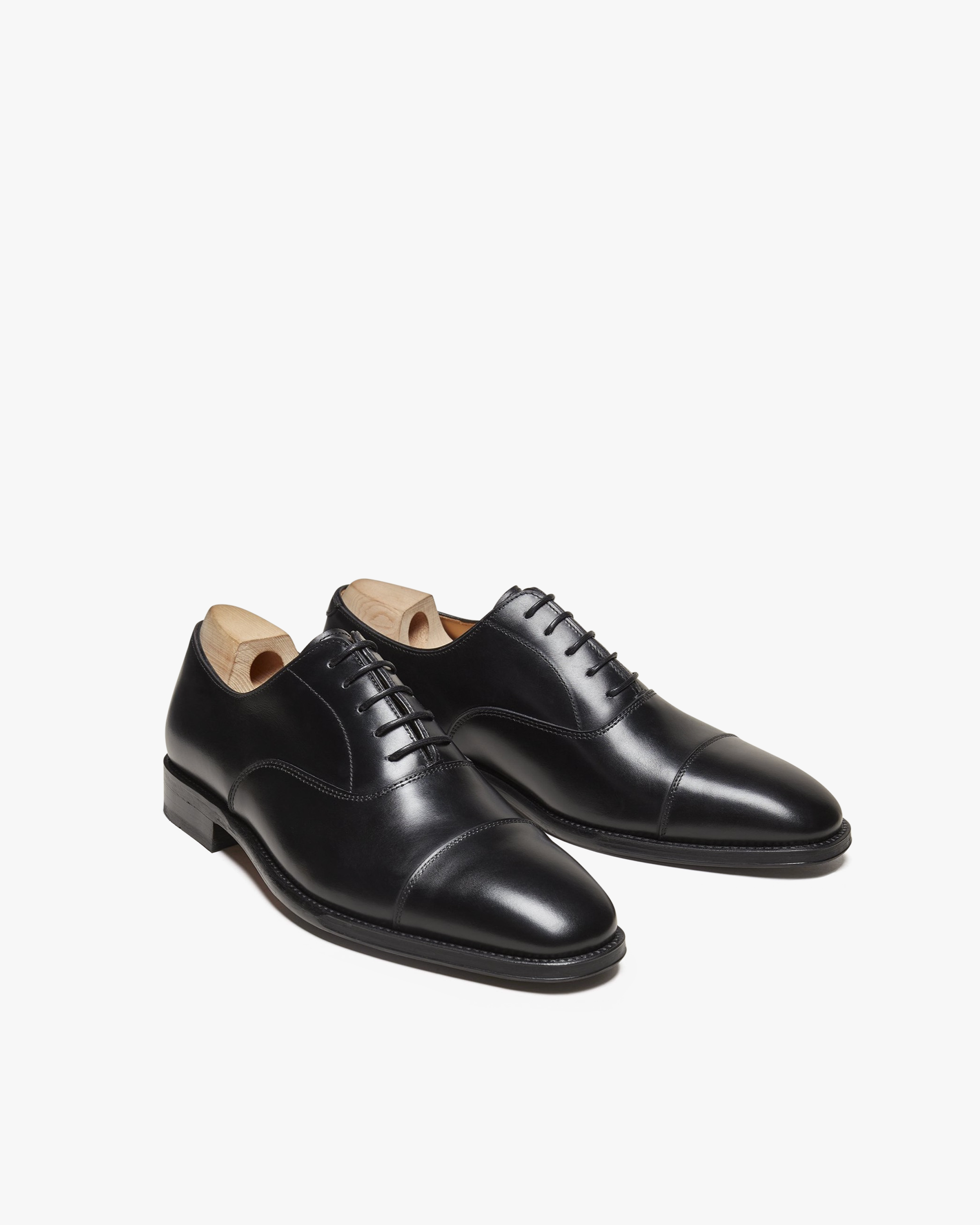 A pair of Vinterviken – Black Calf Oxford shoes, angled to display the cap toe and refined silhouette on a white background.