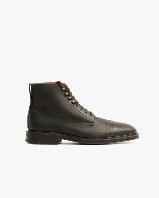 Side profile of the Abisko – Brown Waxed Suede boot, showing its cap-toe design against a white background.
