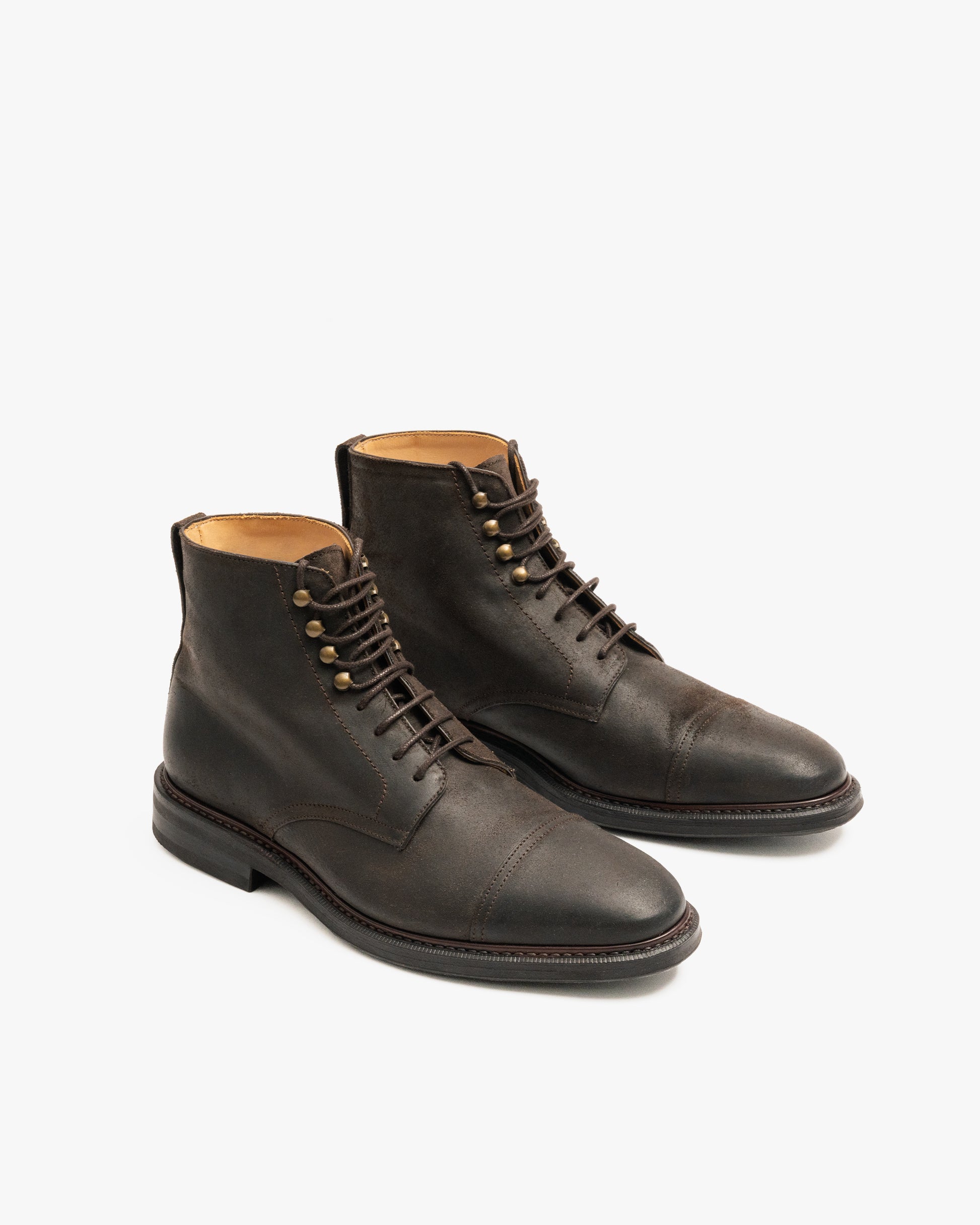 A studio photograph of the Abisko – Brown Waxed Suede boots, shown at an angle to display the cap-toe and hardware.