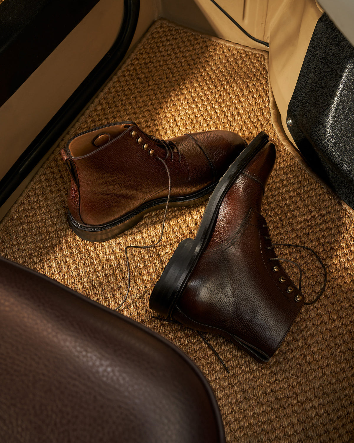 Abisko – Dark Brown Country Calf boots placed on a car floor mat, showcasing their grained upper.