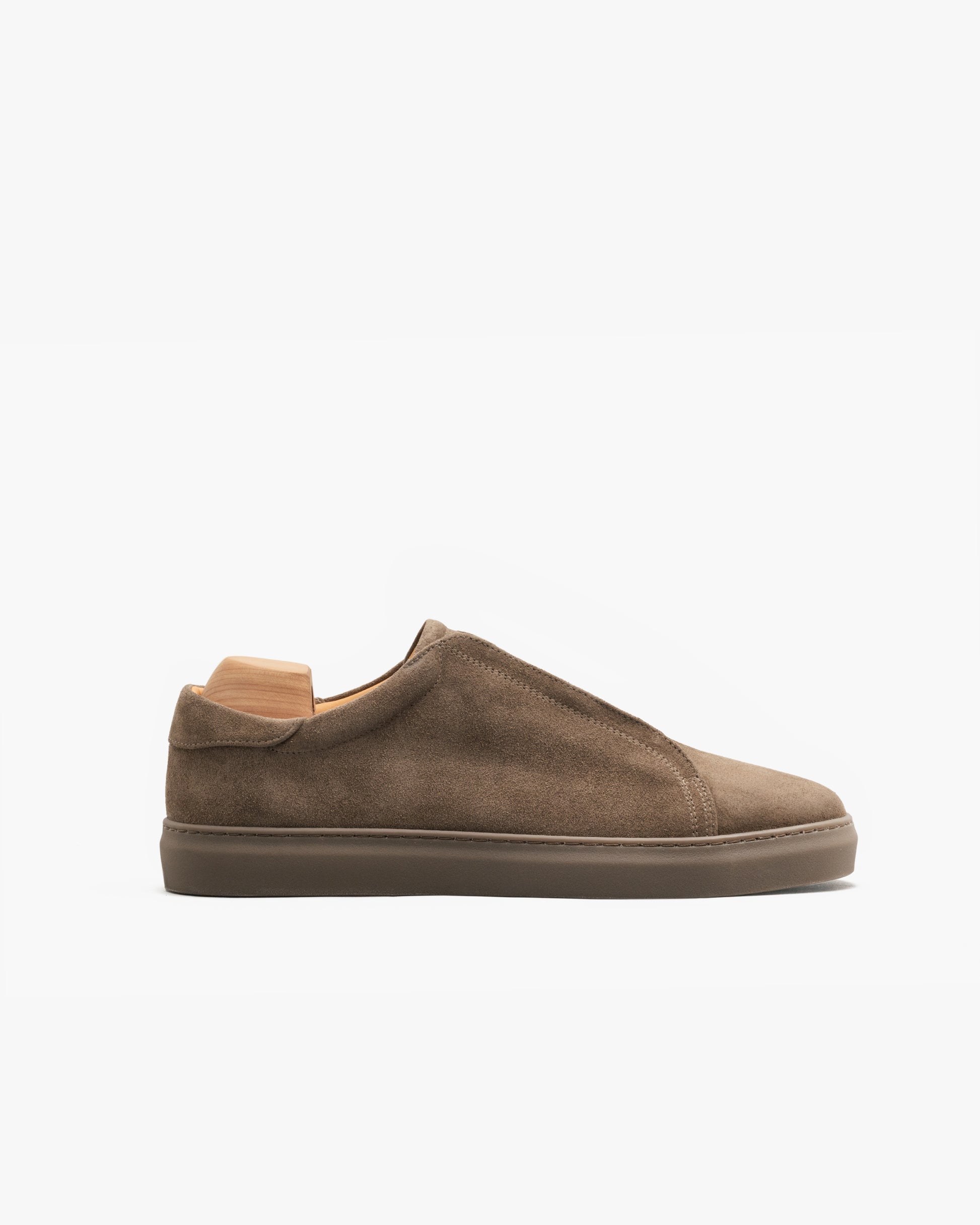 Alnö Monochrome II in taupe suede shown in profile, featuring a minimalist laceless design with soft suede upper, tonal stitching, and a color-matched rubber sole for a cohesive, modern look.