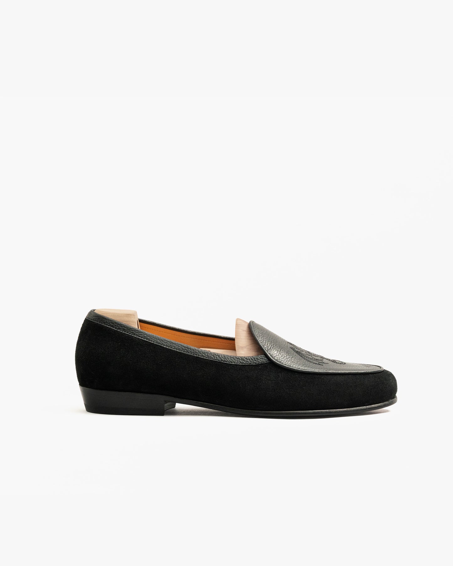 Side profile of Ängby – Fares Edition slipper, showcasing its black suede body and grained leather apron.