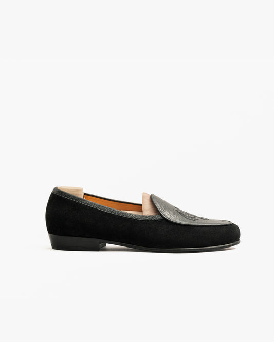 Side profile of Ängby – Fares Edition slipper, showcasing its black suede body and grained leather apron.