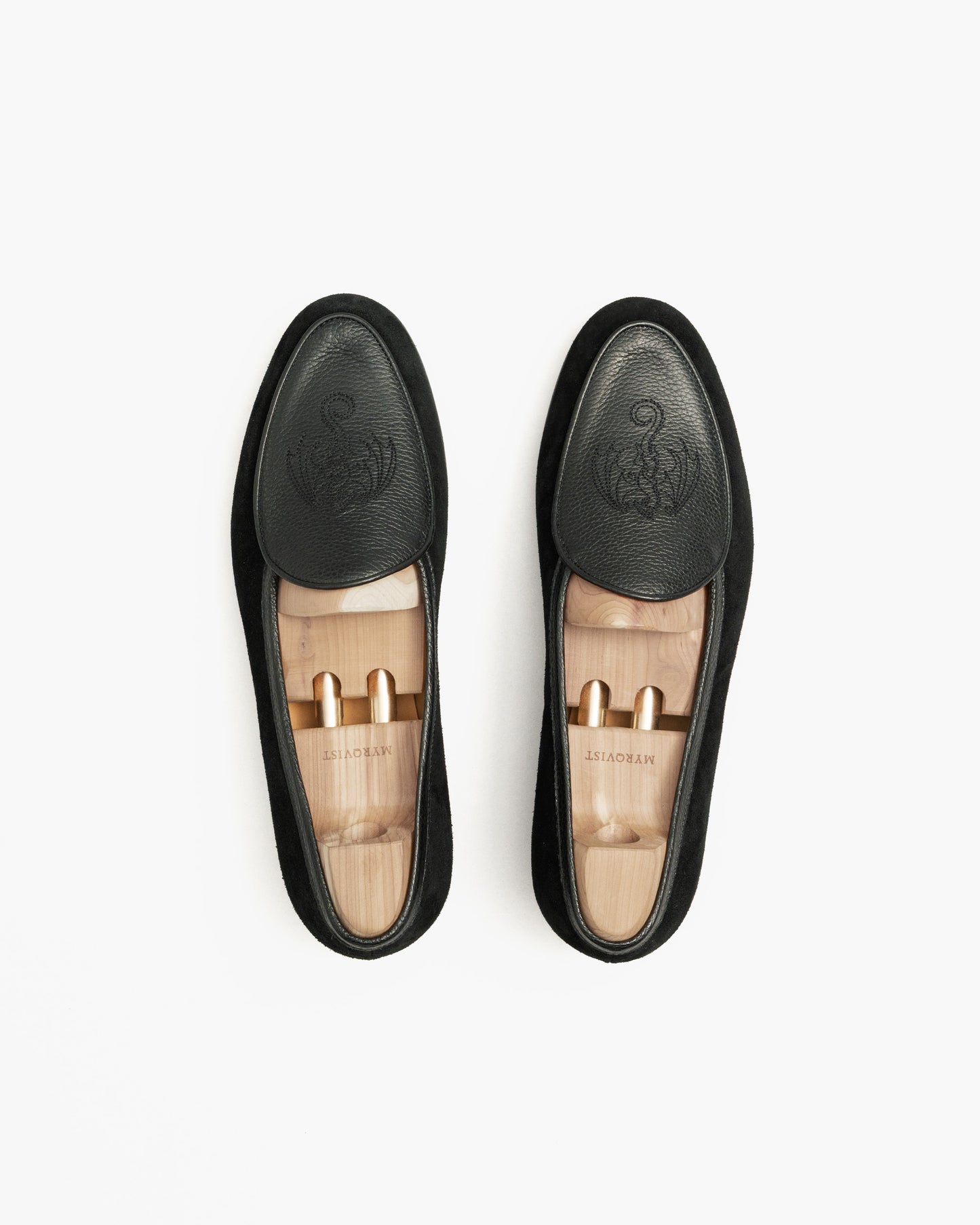 A top-down shot of a pair of Ängby – Fares Edition loafers with wooden shoe trees inside, against a white background.