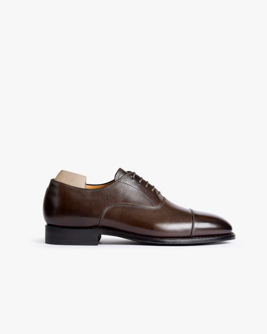 A cap-toe oxford, Äppelviken II – Dark Brown Calf, in smooth leather, shown in a side profile against a white background.