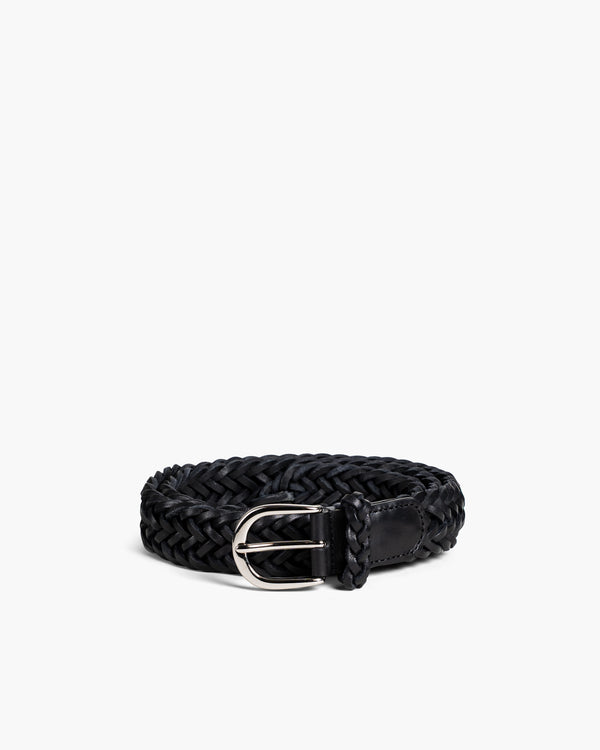 Braided Belt in black leather featuring a hand-woven design, polished silver-toned buckle, and supple texture, styled in a coiled position to highlight its craftsmanship and adjustable fit.