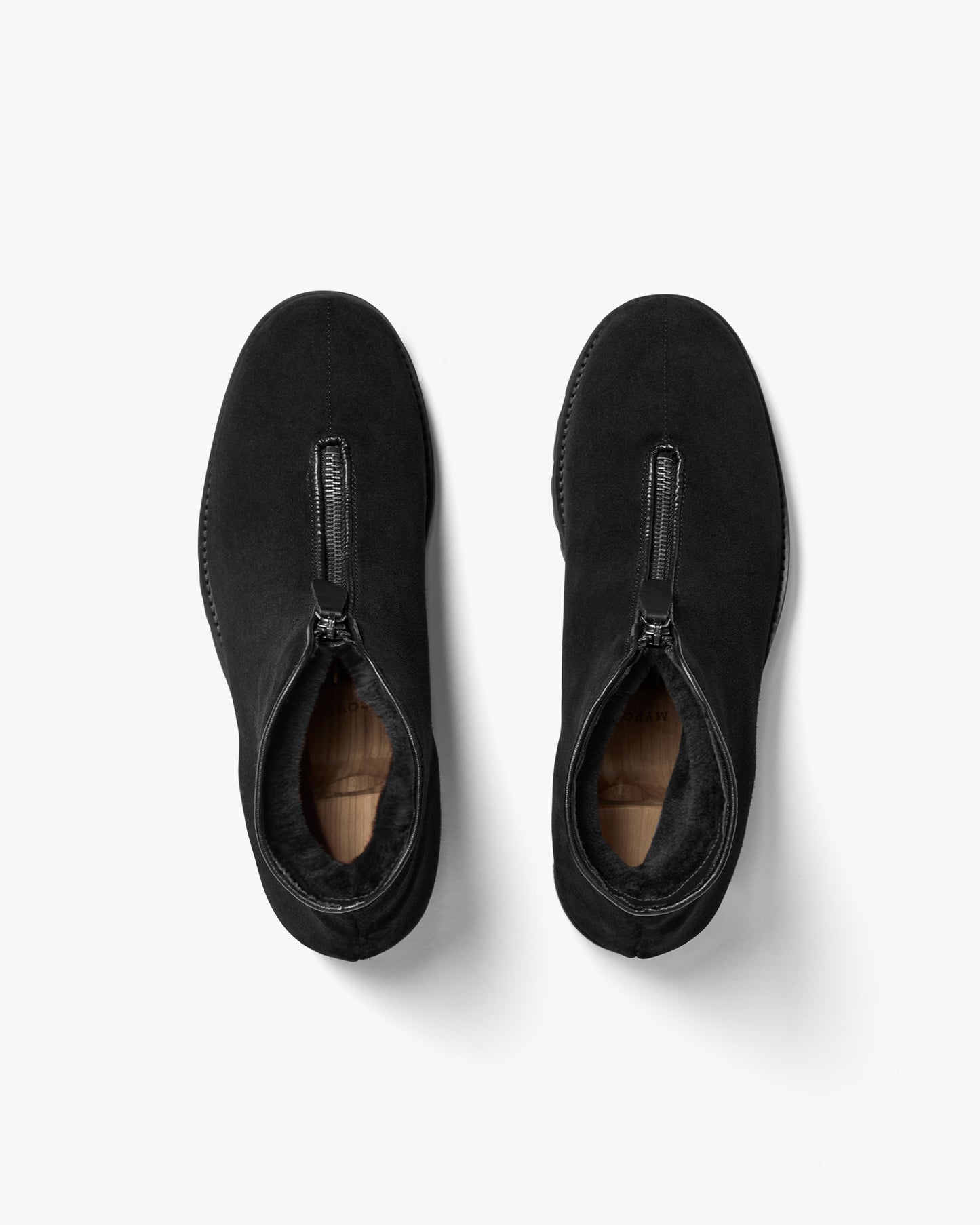 Pair of Funäs in black suede boots shown from above, highlighting the central zip closure, plush shearling lining, and minimalist design ideal for winter wear.