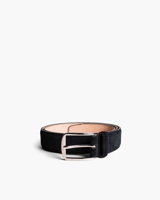 Black suede belt with a silver buckle, featuring precise stitching and a softly textured finish, styled in a coiled position against a white background.