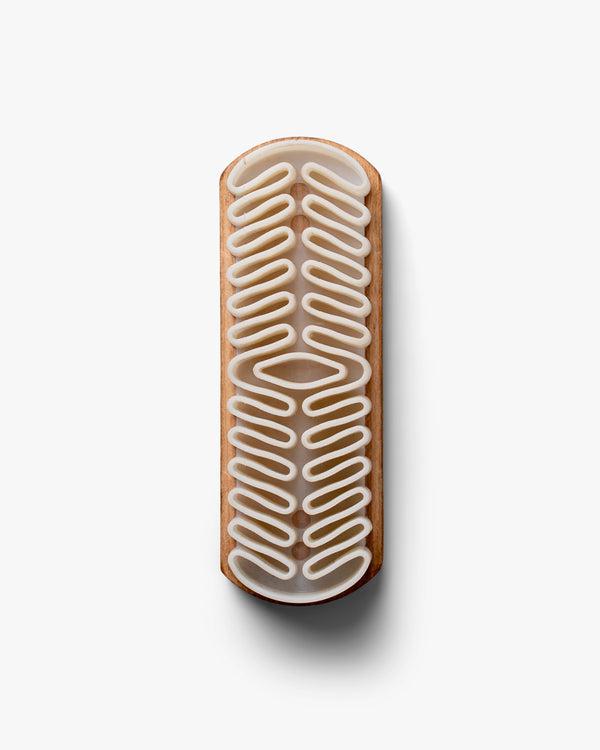 A top-down view of the Suede Brush – Crepe, detailing its wooden handle and textured crepe rubber head.