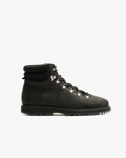 A side profile of the Duved – Black Waxed Suede boot, highlighting its chunky sole and silver hiking eyelets.