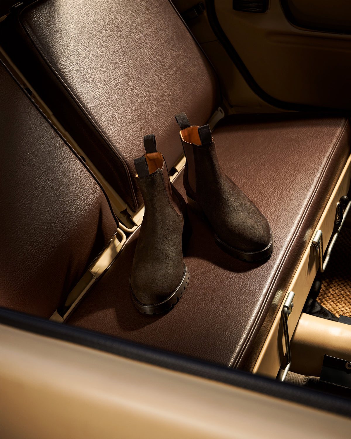 Elfvik II – Brown Waxed Suede Chelsea boots resting on the dark leather interior of a vintage car.