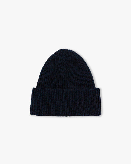 A flat lay of Hat – Merino/Cashmere – Navy, a ribbed knit hat, photographed against a white background.