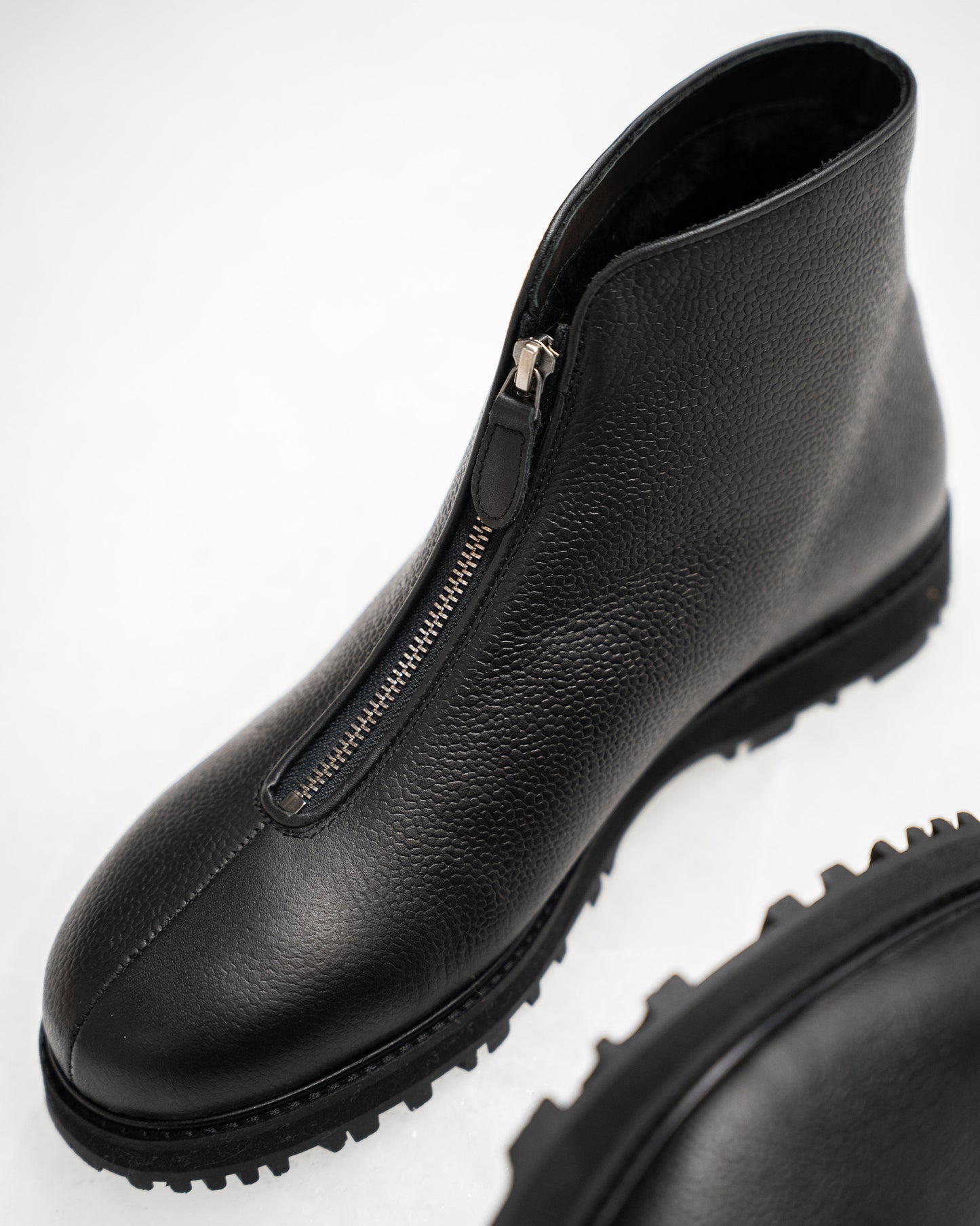 Close-up of Funäs in black country calf, highlighting the textured full-grain leather, central zipper, and robust Explorer sole designed for winter versatility.