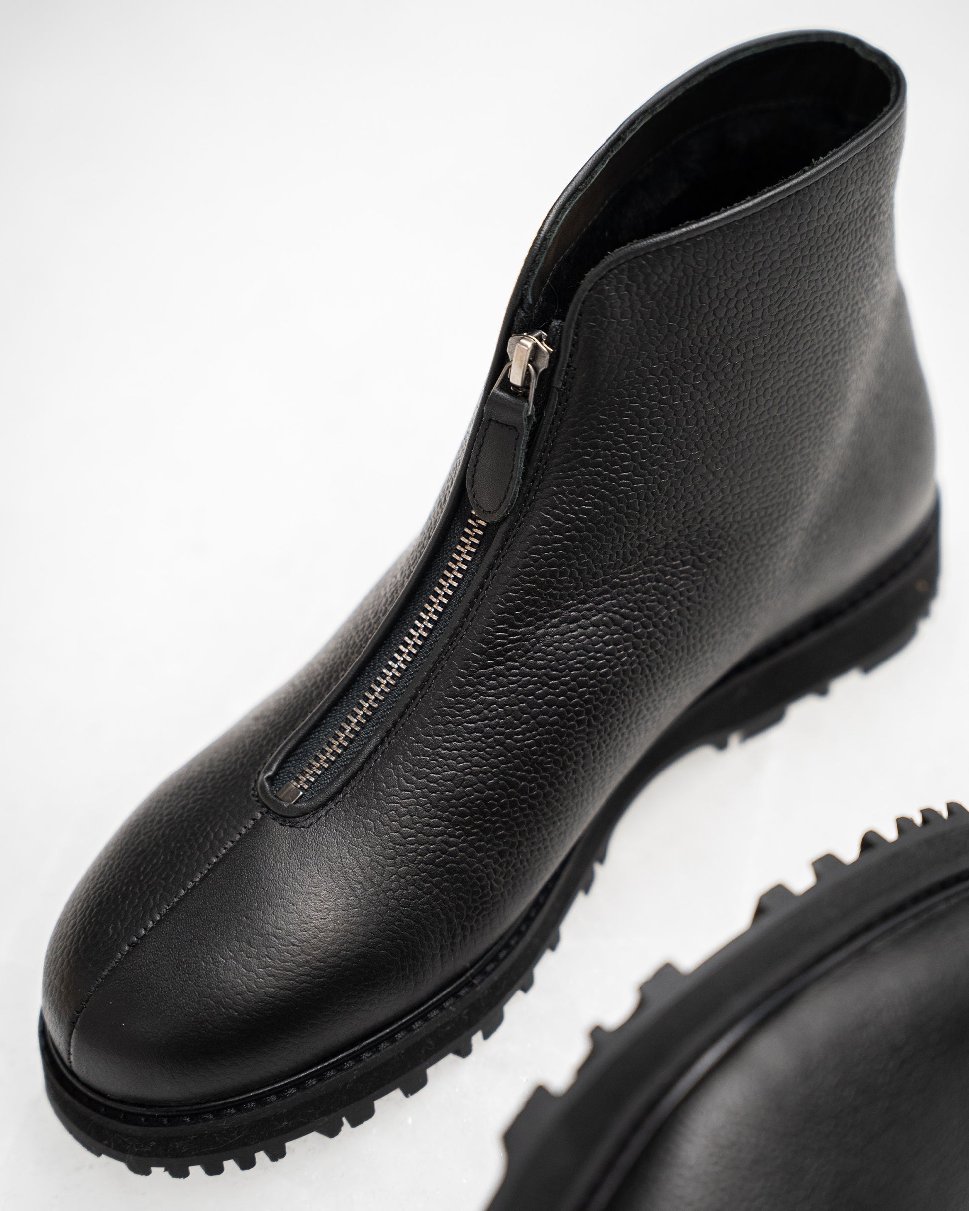 Close-up of Funäs in black country calf, highlighting the textured full-grain leather, central zipper, and robust Explorer sole designed for winter versatility.