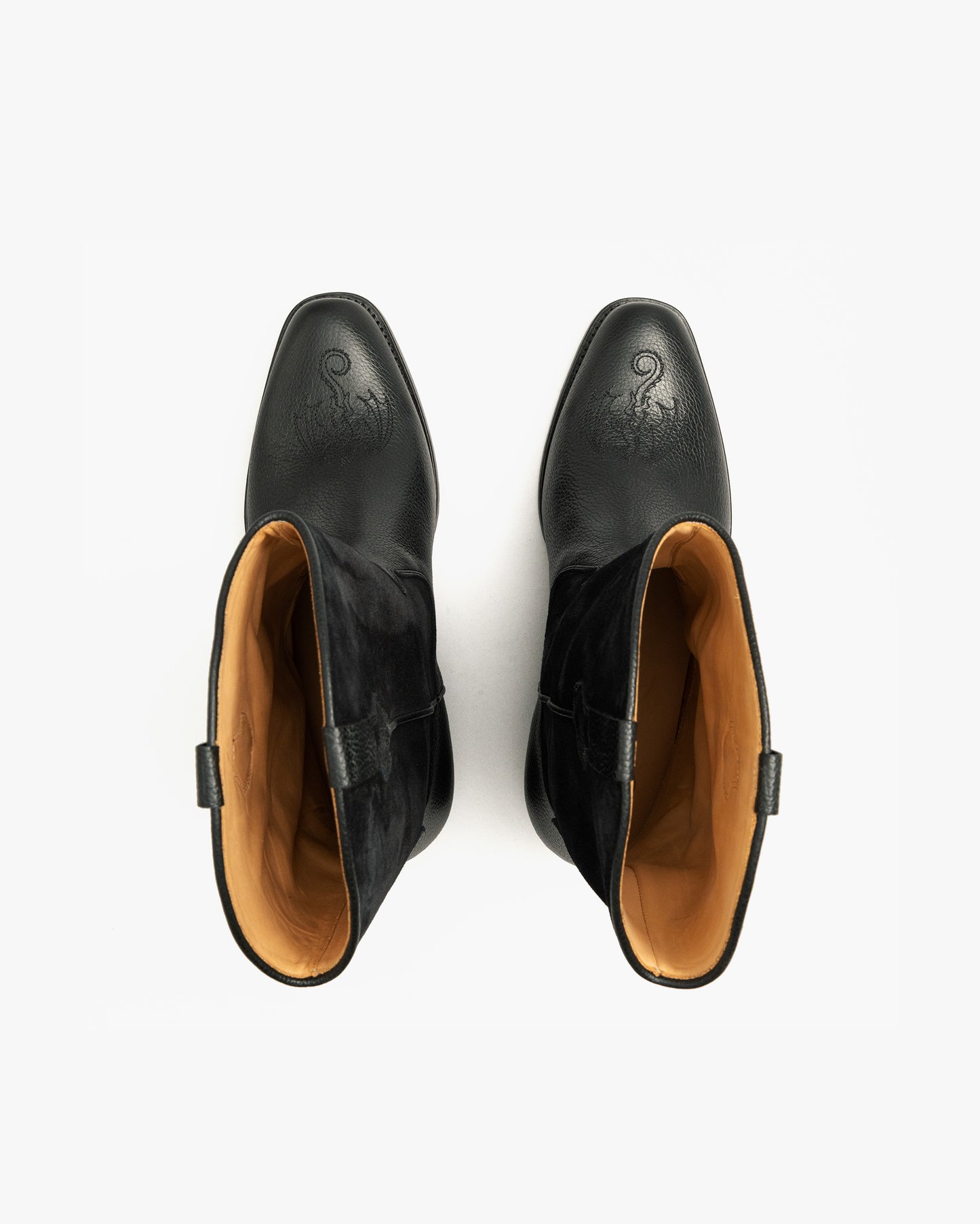 A top-down view of the black Karlslund – Fares Edition boots, showcasing the decorative stitching and tan leather interior.
