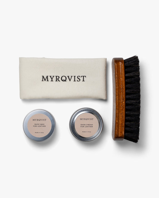 An overhead view of the Myrqvist Shoe Care Kit – Leather, showing the cream, wax, polishing cloth, and brush.