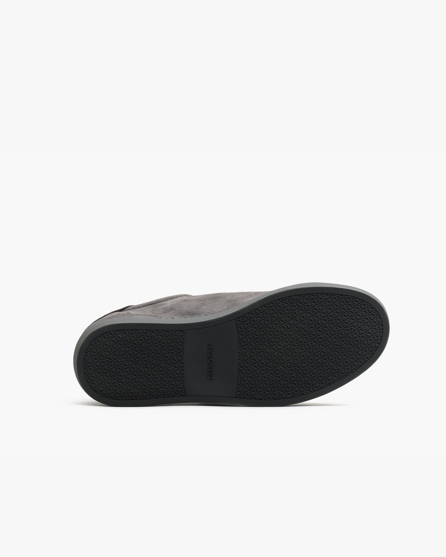 Oaxen Monochrome in dark grey suede shown with the sole facing up, highlighting the textured M-pattern grip and seamless transition between the upper and outsole.