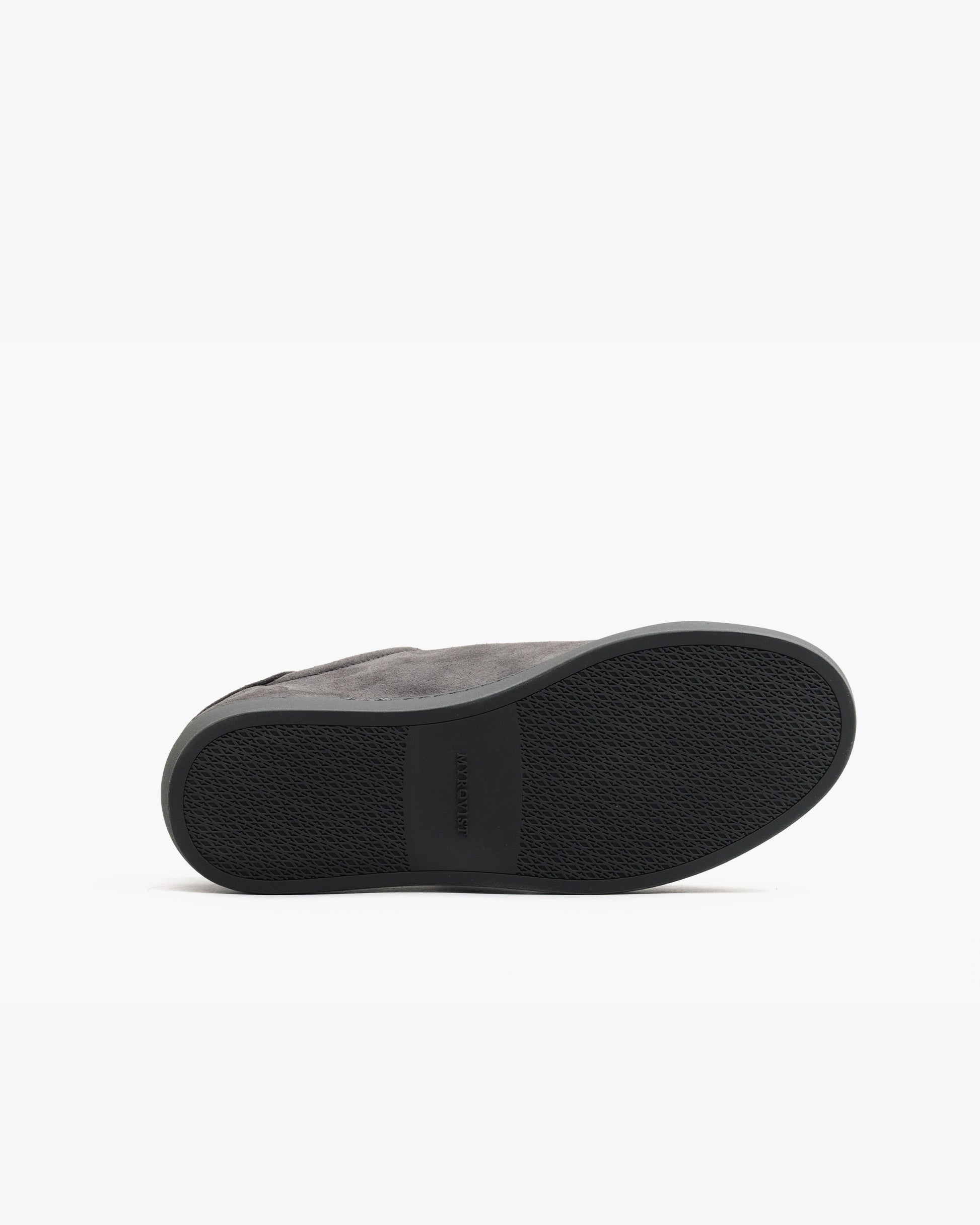 Oaxen Monochrome in dark grey suede shown with the sole facing up, highlighting the textured M-pattern grip and seamless transition between the upper and outsole.
