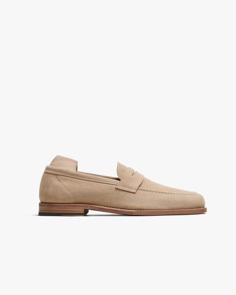 Lysekil II in sand suede displayed in a side profile, featuring a softly textured pale suede upper, classic penny loafer strap, gently rounded toe, and a refined leather sole with subtle stitching details.