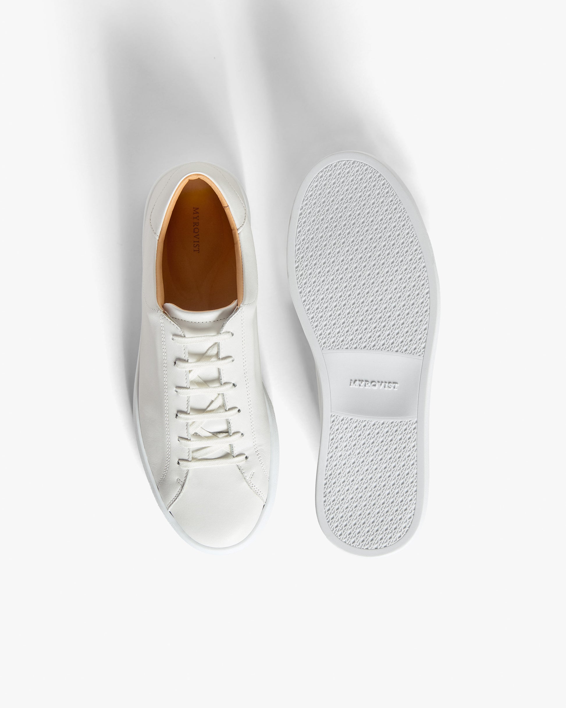 Oaxen – White Calf sneaker shown upright beside another displaying the textured M-pattern sole against a white background.