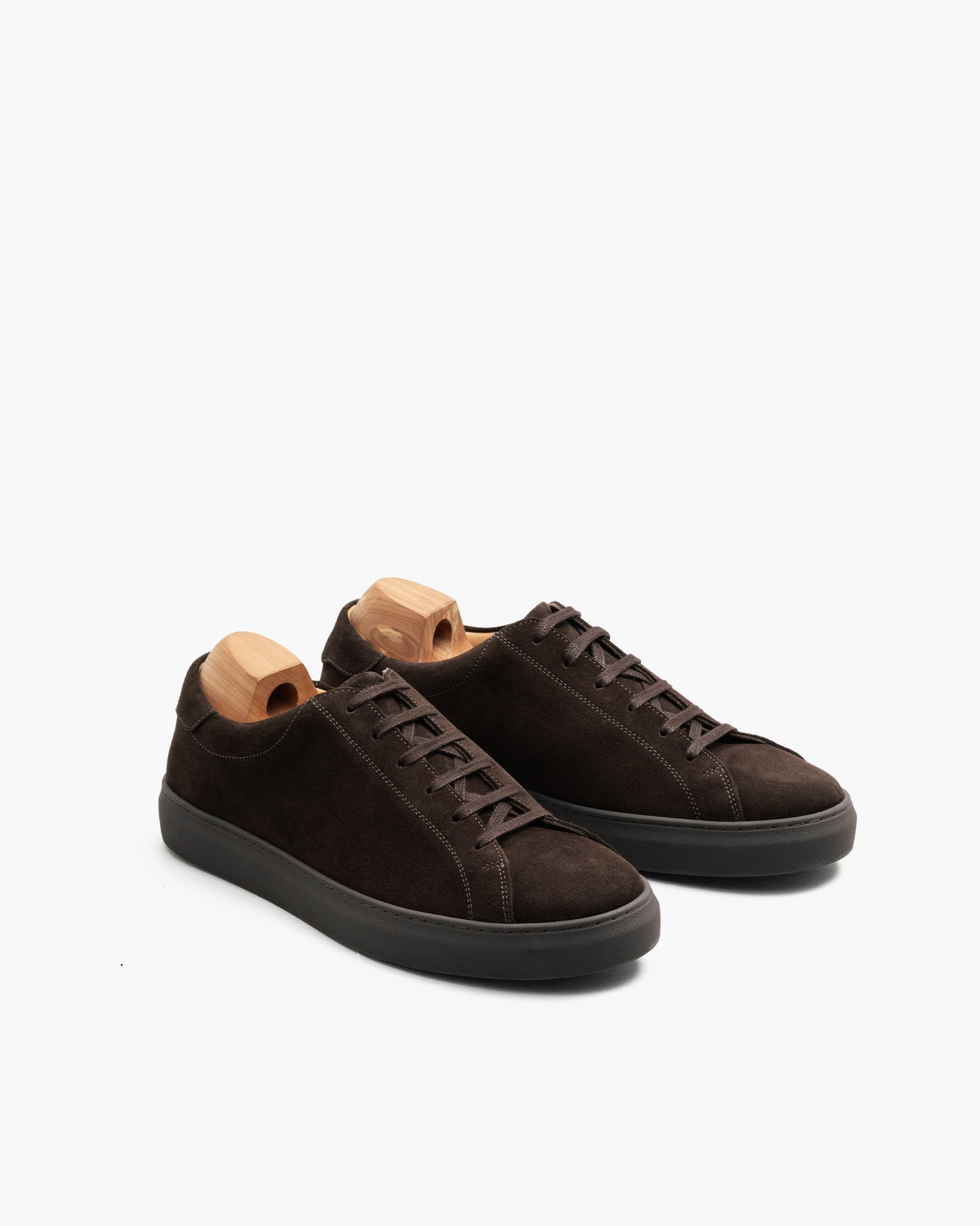 Oaxen Monochrome Sneaker aus dunkelbraunem Wildleder mit Holzschuhspannern, Dreiviertelansicht zeigt die samtige Textur des Obermaterials und die durchgehend braune Farbgestaltung.