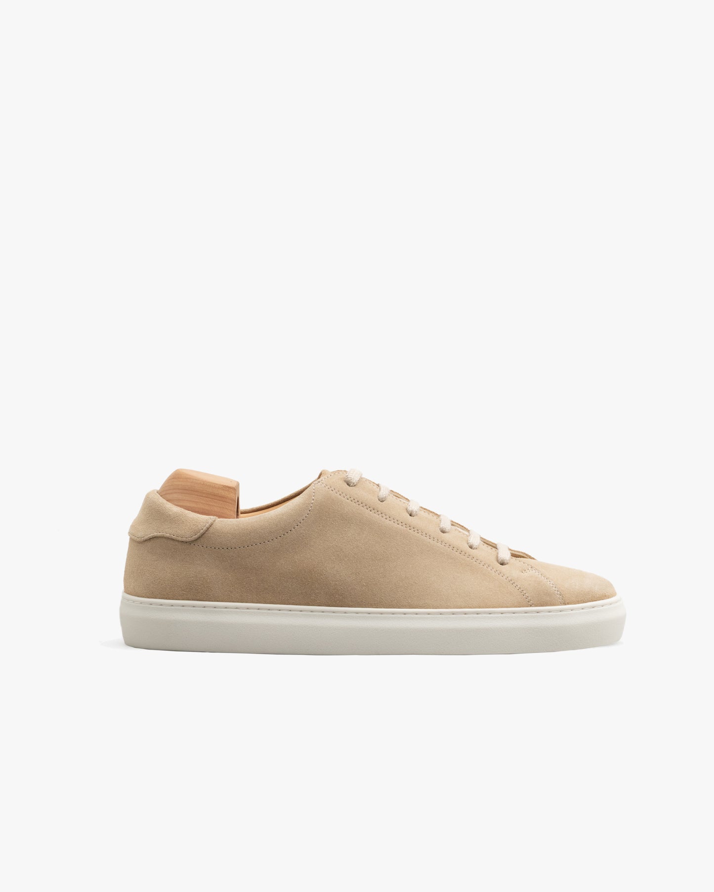 Oaxen in sand suede displayed in a side profile, featuring a minimalist silhouette with tonal stitching, matching laces, and a sculpted off-white cup sole, set against a clean white background.