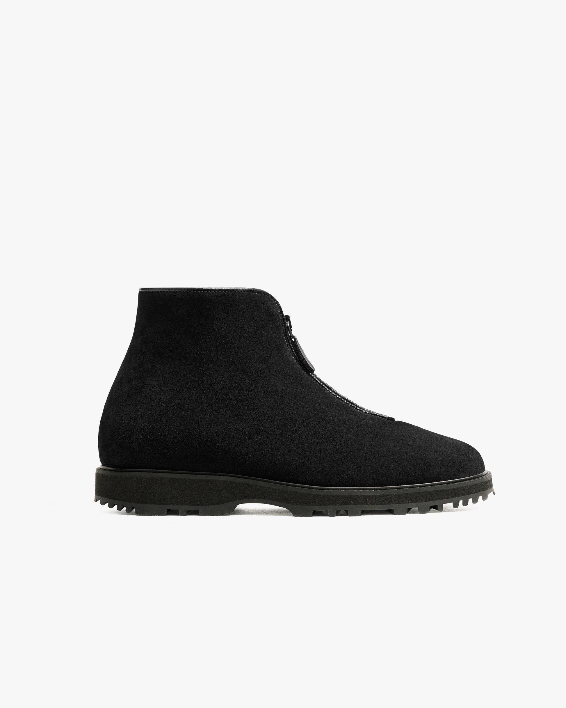 Minimalist black suede boot with a central zipper, rugged Explorer sole, and clean silhouette, designed for versatile wear in both formal and casual winter settings.