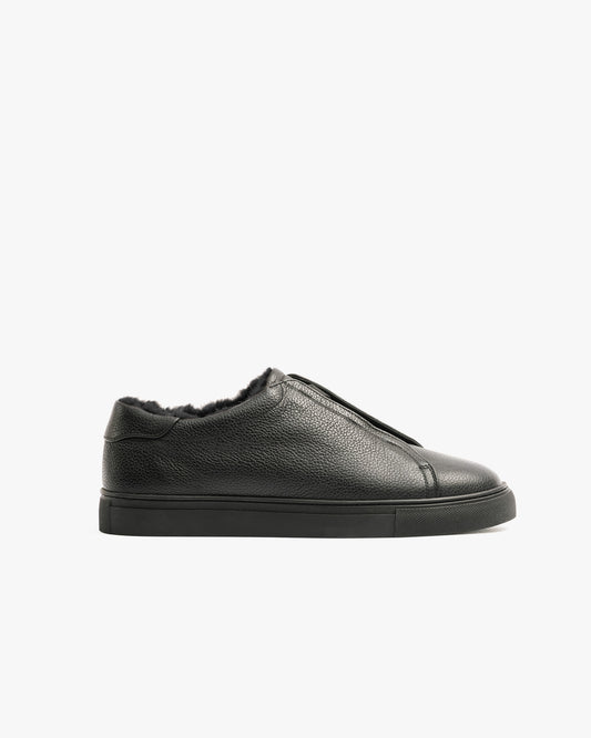 Profile view of Alnö Shearling – Black Natural Grain sneaker, highlighting its textured leather and shearling lining.