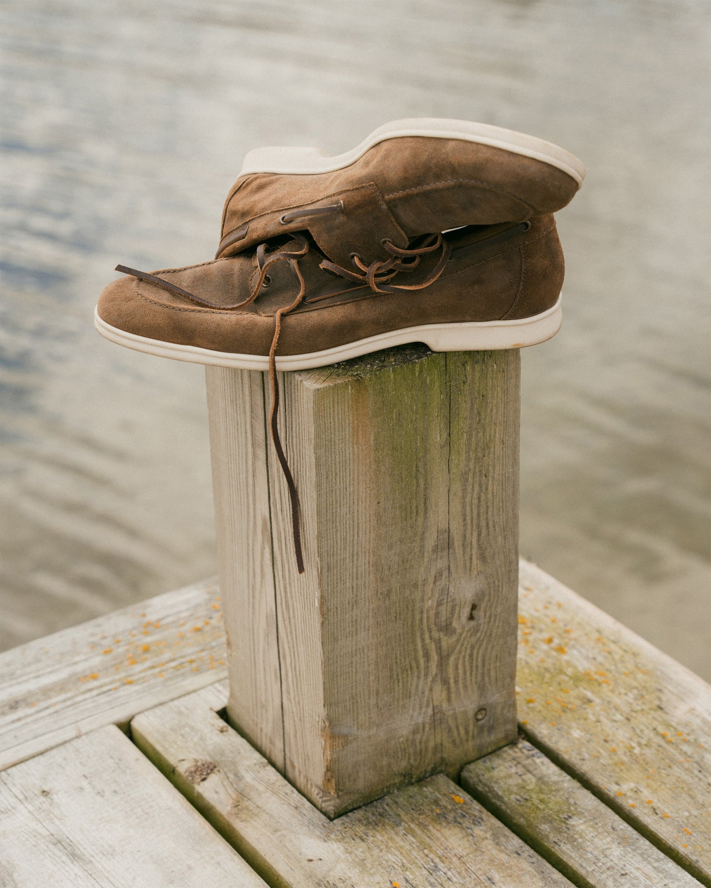Sandhamn – Chestnut Waxed Suede loafers on a wooden dock by the water.