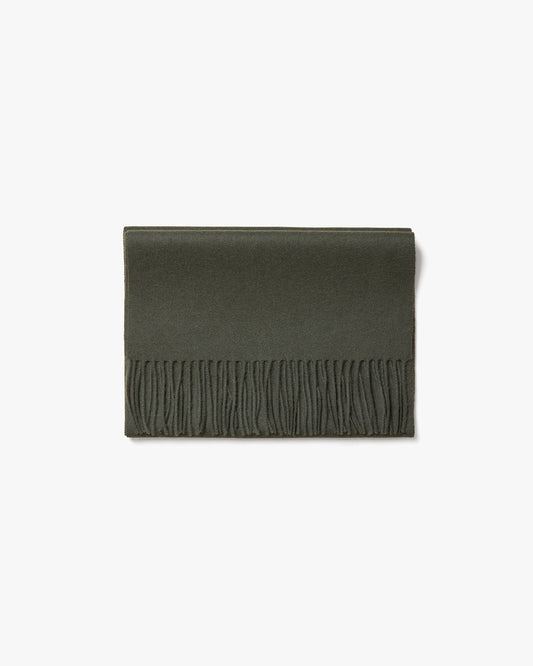 The Wool Scarf – Dark Green, neatly folded to display its texture and fringed edge against a white background.