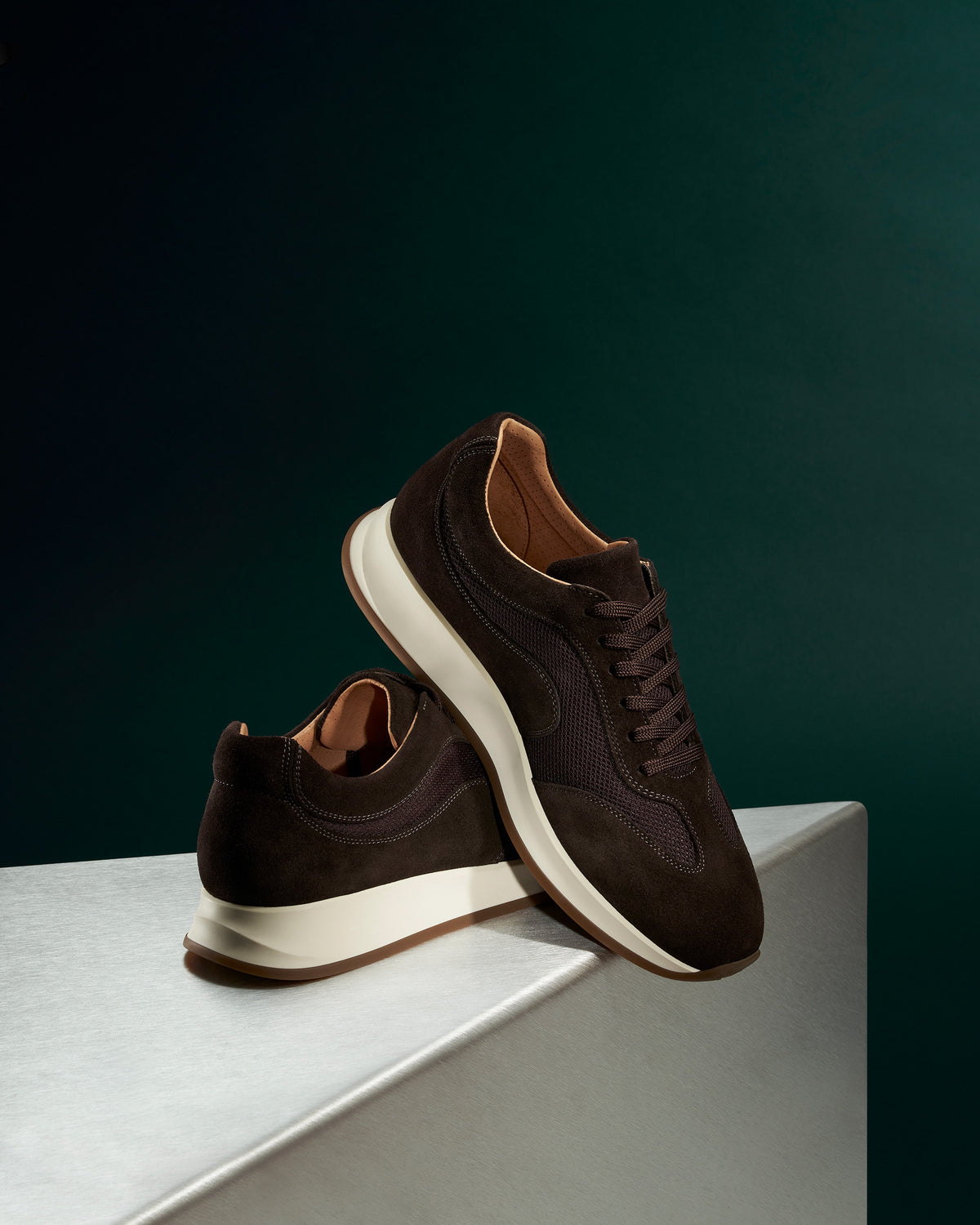 Stensund II – Dark Brown Suede sneakers combining soft suede and mesh panels on a metallic surface.