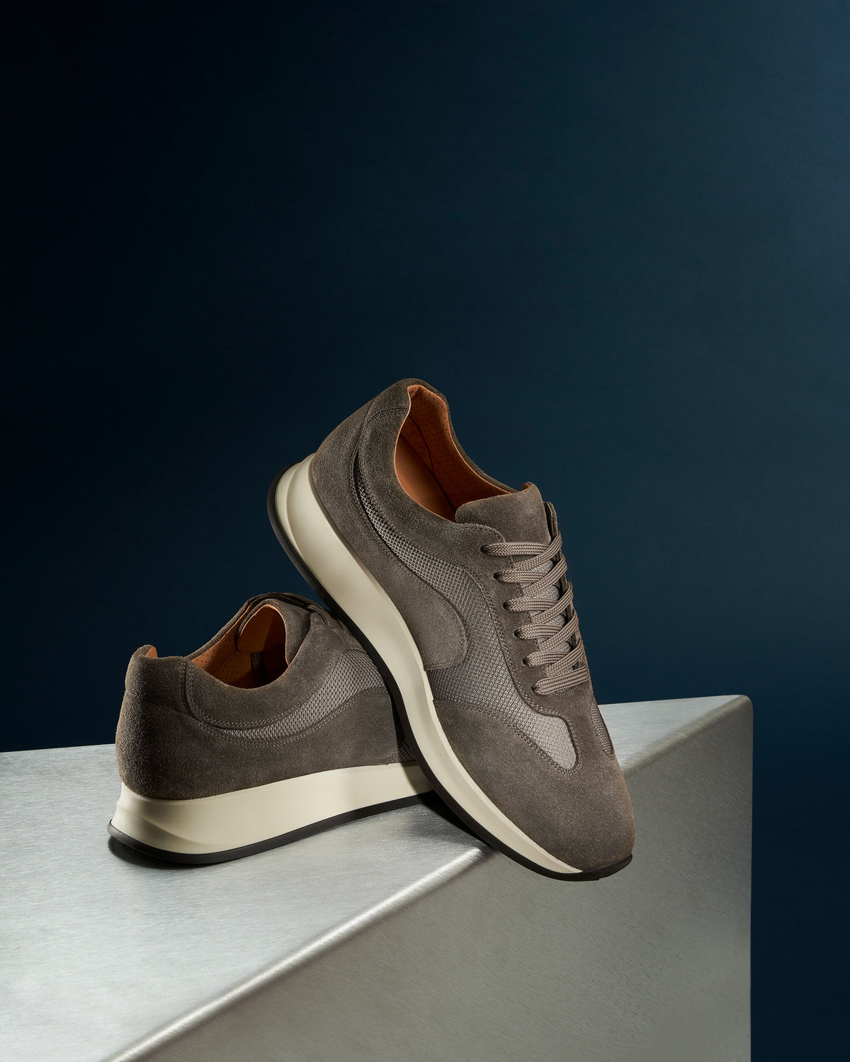 Stensund II – Taupe Suede sneakers featuring soft suede and mesh panels displayed on a metallic surface.