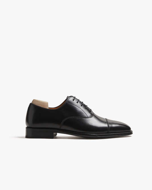 Vinterviken II in black calf, a classic cap toe oxford shoe, features smooth full-grain leather with refined stitching and a gently rounded toe, presented against a clean white background to highlight its elegant silhouette and polished finish.