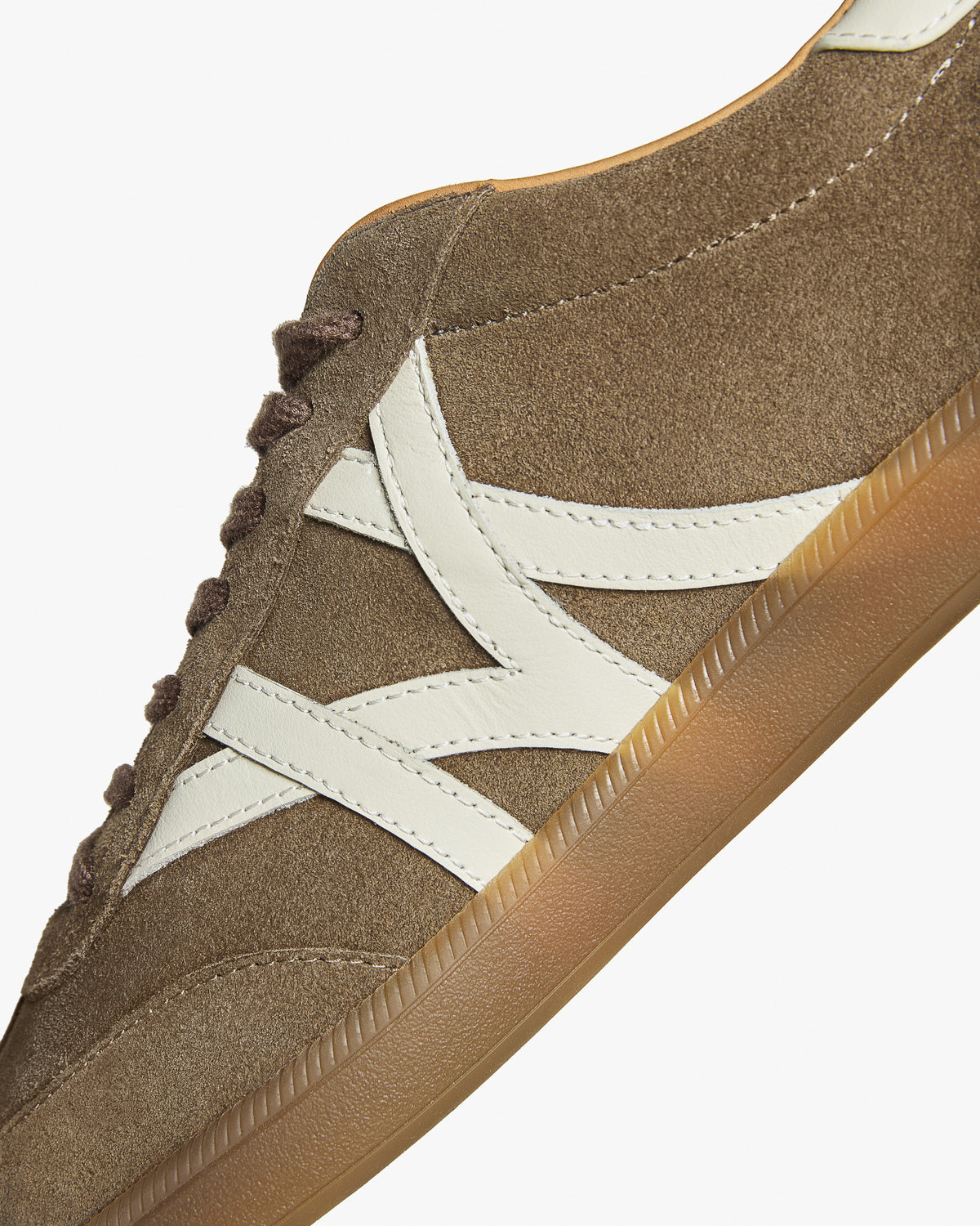 Högalid – Taupe Suede detail showing the taupe suede upper, contrasting side stripes, and gum sole.
