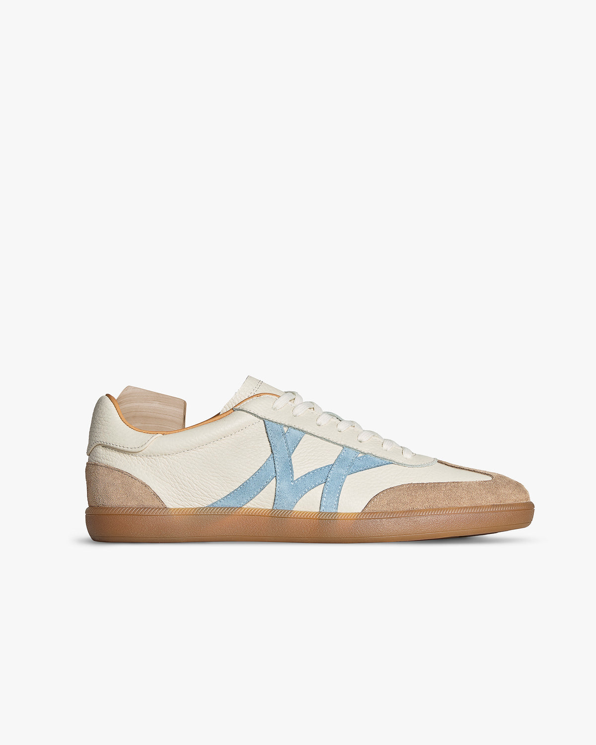 Högalid – White Natural Grain sneaker in profile, showing white leather, light blue M-pattern panels, and gum sole.