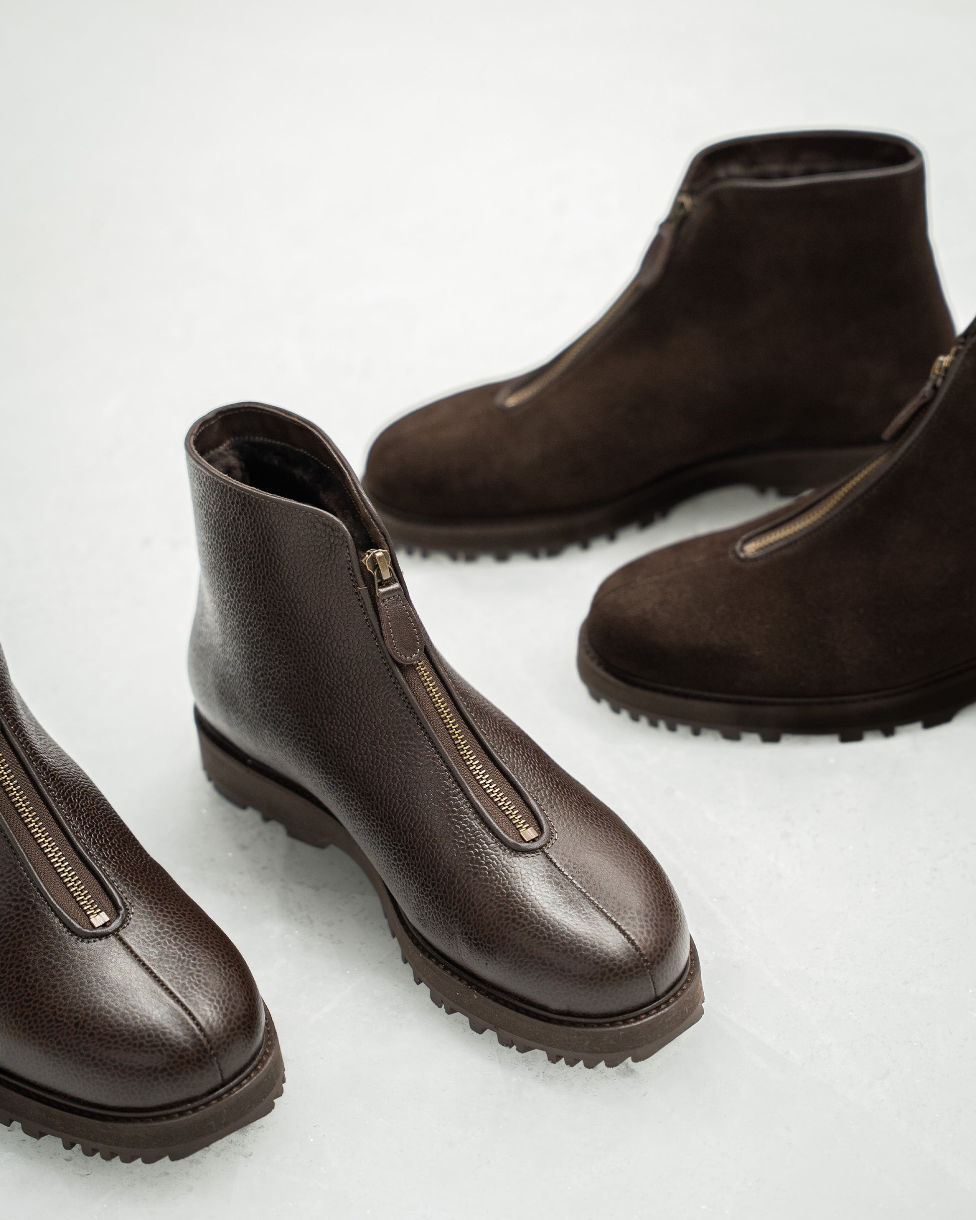 A studio shot of Funäs – Dark Brown Country Calf, with the suede version of the boot visible in the background.